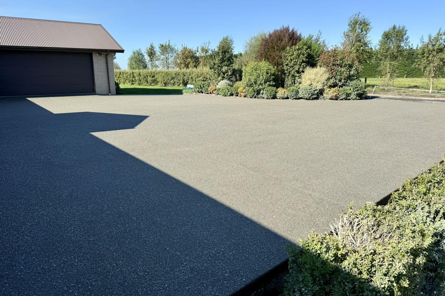 Exposed aggregate concrete driveway leading to a modern home entrance, Ashburton
