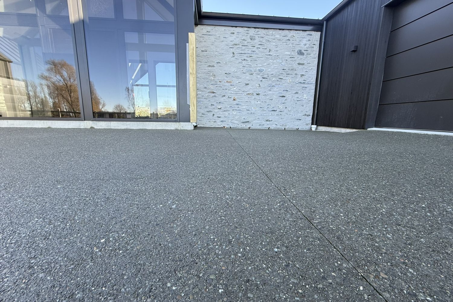 Close-up of exposed aggregate concrete finish with light and shadow texture, Ashburton